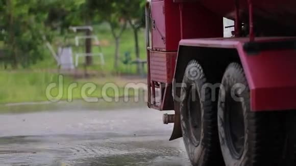 不明身份的亚洲工人用一个强大的软管喷雾器冲洗道路视频的预览图