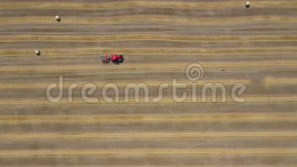 干草加工成圆捆的鸟瞰图红色拖拉机在田间工作视频的预览图