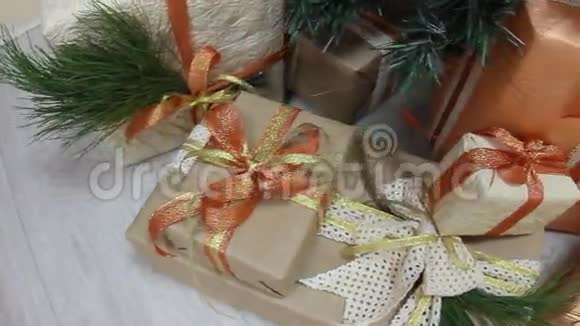 礼物在装饰圣诞树下的盒子里放着玩具和白光闪烁的花环移动摄像机视频的预览图