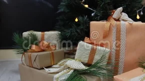 礼物在装饰圣诞树下的盒子里放着玩具和白光闪烁的花环移动摄像机视频的预览图