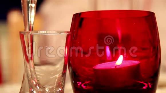 在一个红玻璃杯和一个小玻璃杯里的烛光视频的预览图