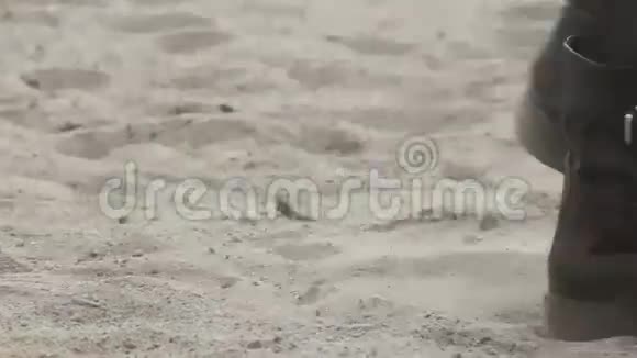 女孩的腿她穿着黑色的鞋子走在沙滩上近距离射击视频的预览图