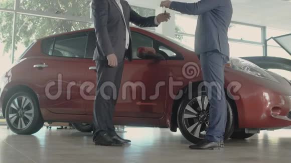 售货员把新车的钥匙交给汽车经销店的顾客视频的预览图