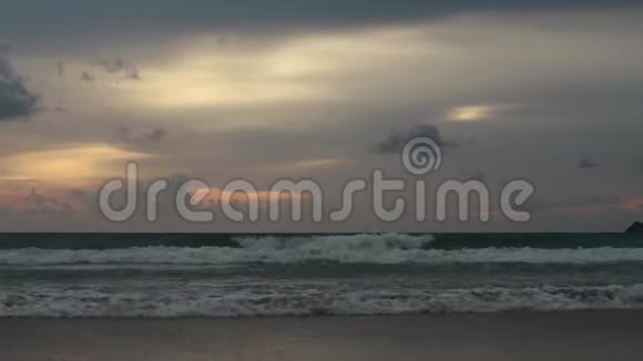 日落时的海景反射在潮湿的沙滩上海浪涌来视频的预览图