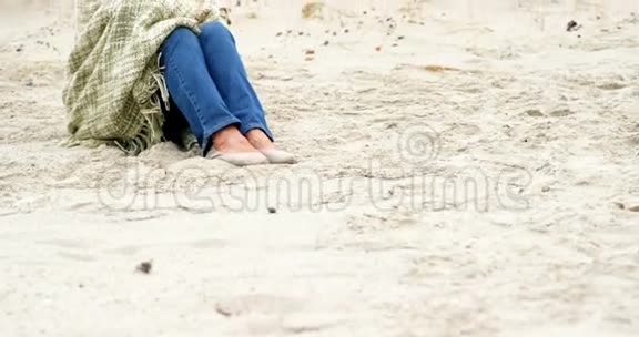 坐在沙滩上体贴的退休妇女视频的预览图