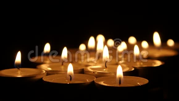 许多在黑暗背景上燃烧的小蜡烛关门视频的预览图