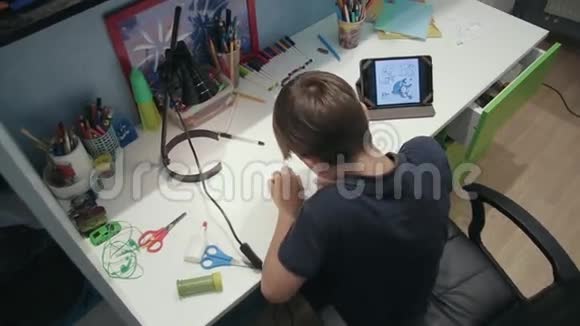 一个小男孩在用数码平板电脑拷贝照片视频的预览图
