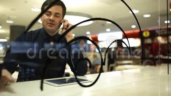 在咖啡馆里拿着便签的商人在打电话视频的预览图
