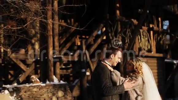 新婚夫妇在冬天的公园里的雪地里取暖视频的预览图