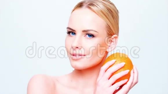 穿着橙色水果的白种人金发女孩视频的预览图