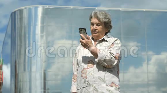 老年妇女在户外使用智能手机交谈视频的预览图