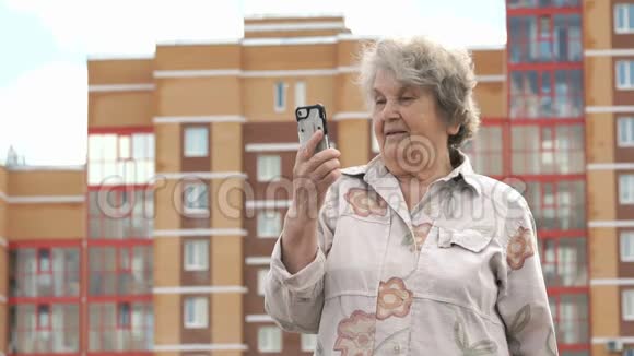 老年妇女在户外使用智能手机交谈视频的预览图
