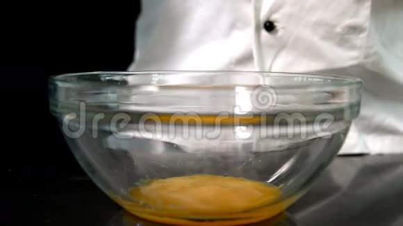 厨师在玻璃碗中加入生鸡蛋视频的预览图