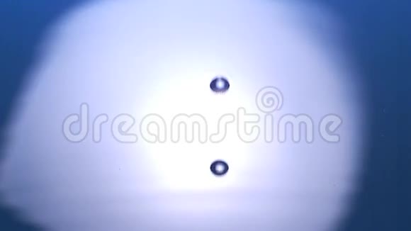 蓝色背景下的水滴落入水中视频的预览图