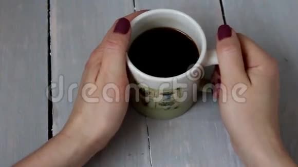 女人喝咖啡木桌视频的预览图