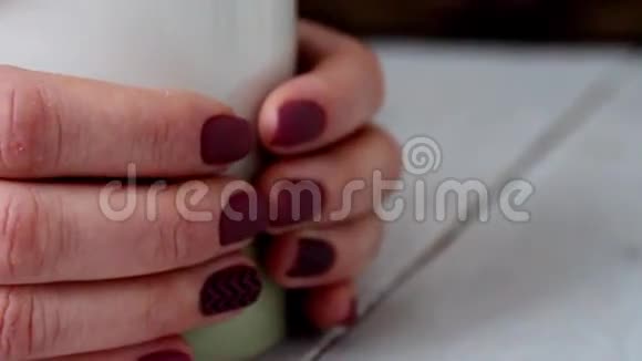 女人喝咖啡木桌视频的预览图