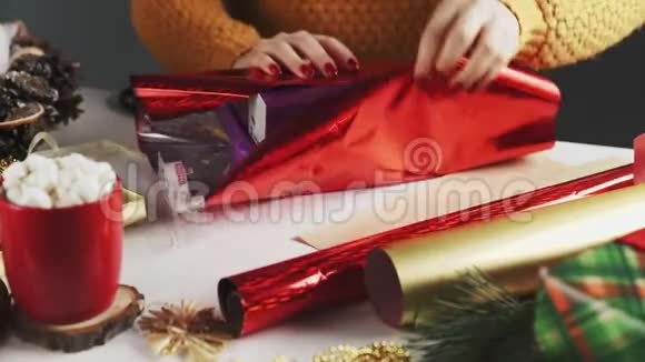 女人用红纸包装圣诞手工礼物视频的预览图
