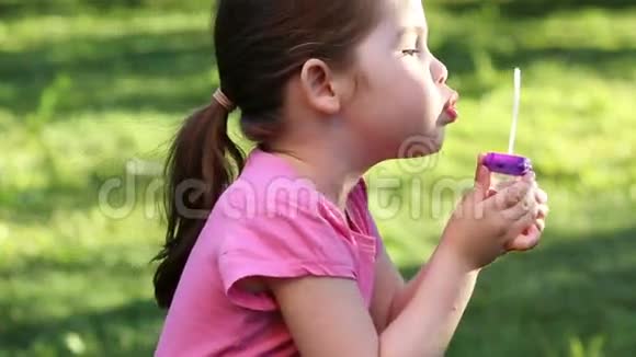 快乐的孩子在公园里吹肥皂泡视频的预览图