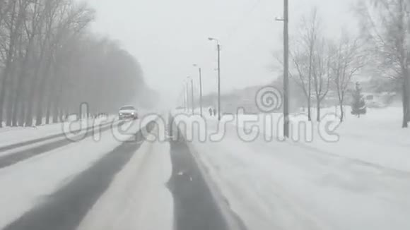 小镇附近的汽车路上大雪纷飞人们走路视频的预览图