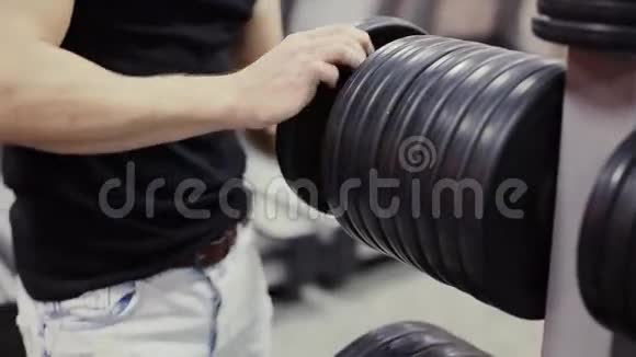 健美运动员在健身房的杠铃上改变体重视频的预览图