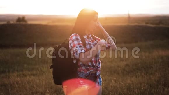 年轻姑娘背着背包走着在峰后欣赏日落背景视图上的游客模型慢视频的预览图