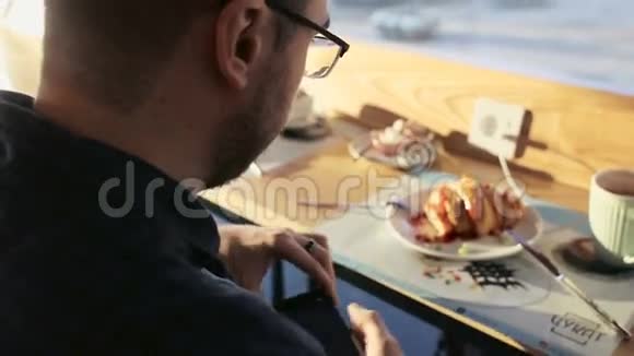 帅哥在咖啡馆里用手机聊天视频的预览图