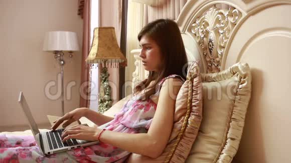 一个在床上用电脑工作的年轻女孩社会网络视频的预览图
