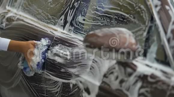 男人用泡沫清洗豪华汽车昂贵的洗车服务商务视频的预览图