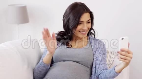 孕妇在家里用智能手机视频聊天视频的预览图