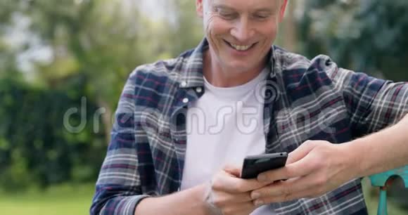 男人在花园里用手机视频的预览图