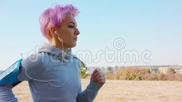 带着粉色头发的年轻女士在郊区慢跑视频的预览图
