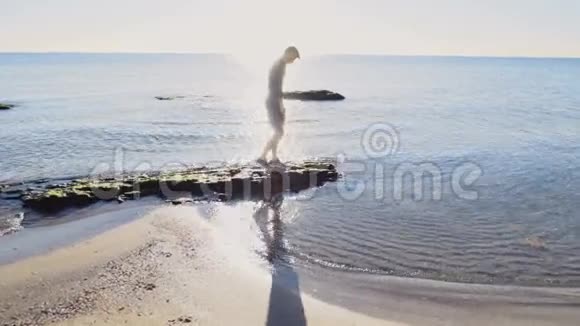 年轻人在阳光下漫步在沙滩上慢动作视频的预览图