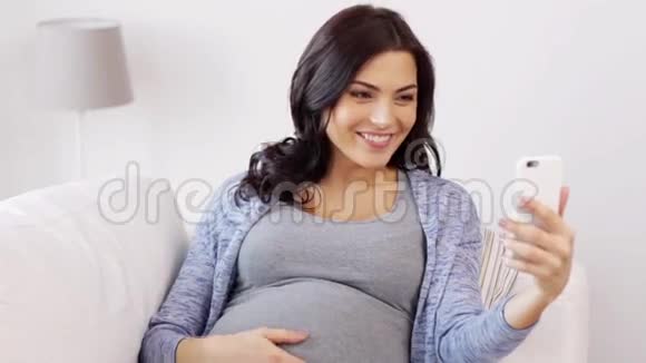 孕妇在家里用智能手机视频聊天视频的预览图