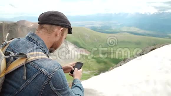 游客在岩石峰上用智能手机拍照视频的预览图