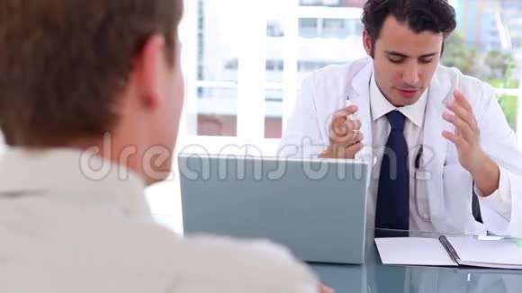 严肃的医生坐着和病人说话视频的预览图