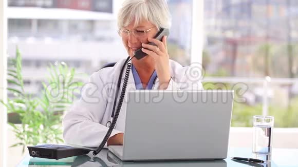 微笑成熟的医生用她的手机视频的预览图