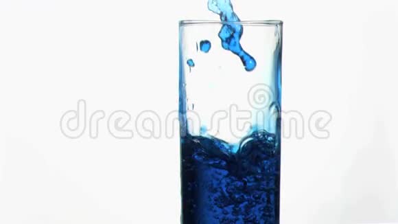 蓝色液体在超慢的运动中溢出在靠近边缘的玻璃中视频的预览图