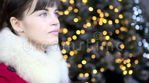 带着金球的圣诞女人在灯光背景下微笑视频的预览图