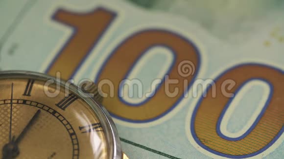 旧表放在桌子上放在一百美元钞票上视频的预览图