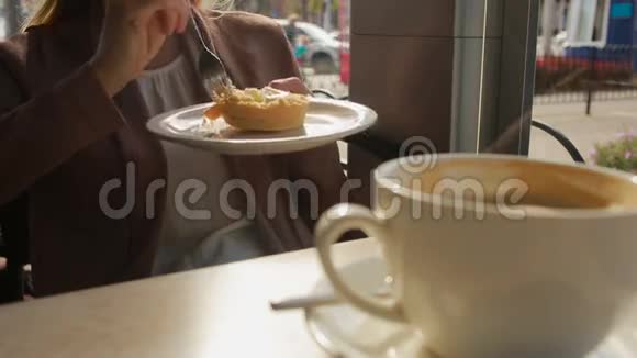 在户外咖啡馆吃蛋糕的女人芝士蛋糕特写视频的预览图