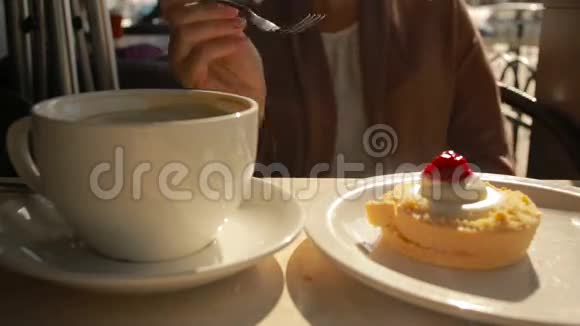 在户外咖啡馆吃蛋糕的女人芝士蛋糕特写视频的预览图