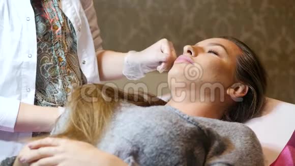 美容柜里的女人宇宙学家正在注射女人头部接受注射的概念视频的预览图