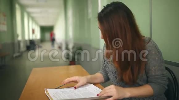 女老师检查坐在办公桌前的家庭作业视频的预览图