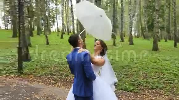 新婚夫妇一对快乐的新婚夫妇在夏季公园视频的预览图