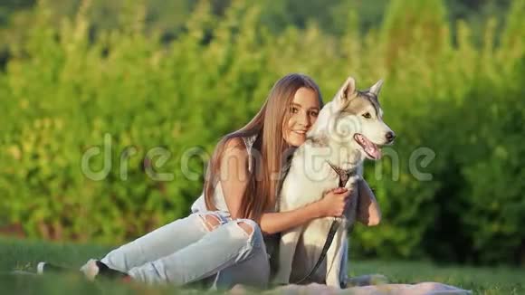 漂亮的年轻女人拥抱滑稽的西伯利亚哈士奇狗视频的预览图