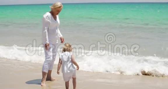 祖母和小女孩在海滩上享受视频的预览图