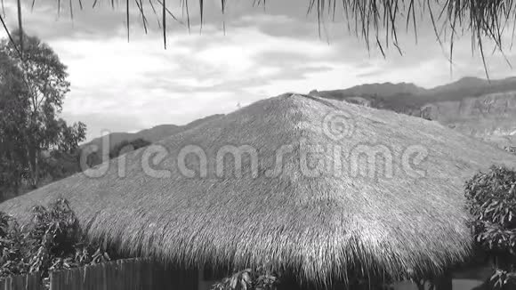 山和天空背景上的茅草屋顶黑白射击视频的预览图