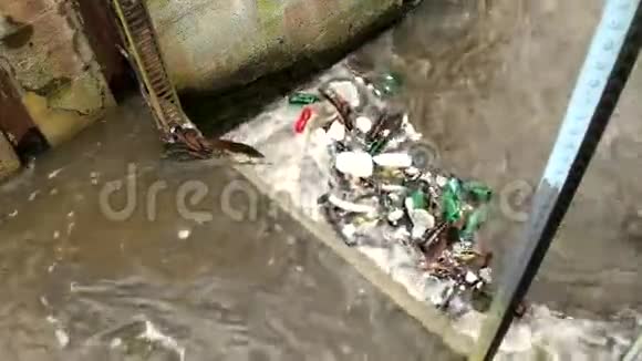 塑料瓶和另一个混乱打开水位河水带着浑浊的水在小河上翻着脏水视频的预览图