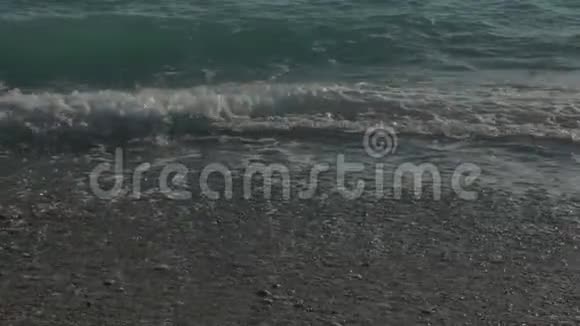 带有泡沫的大透明波海石海滩五颜六色的石头视频的预览图