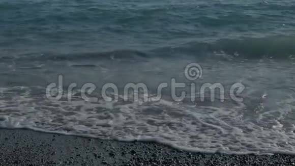 带有泡沫的大透明波海石海滩五颜六色的石头视频的预览图